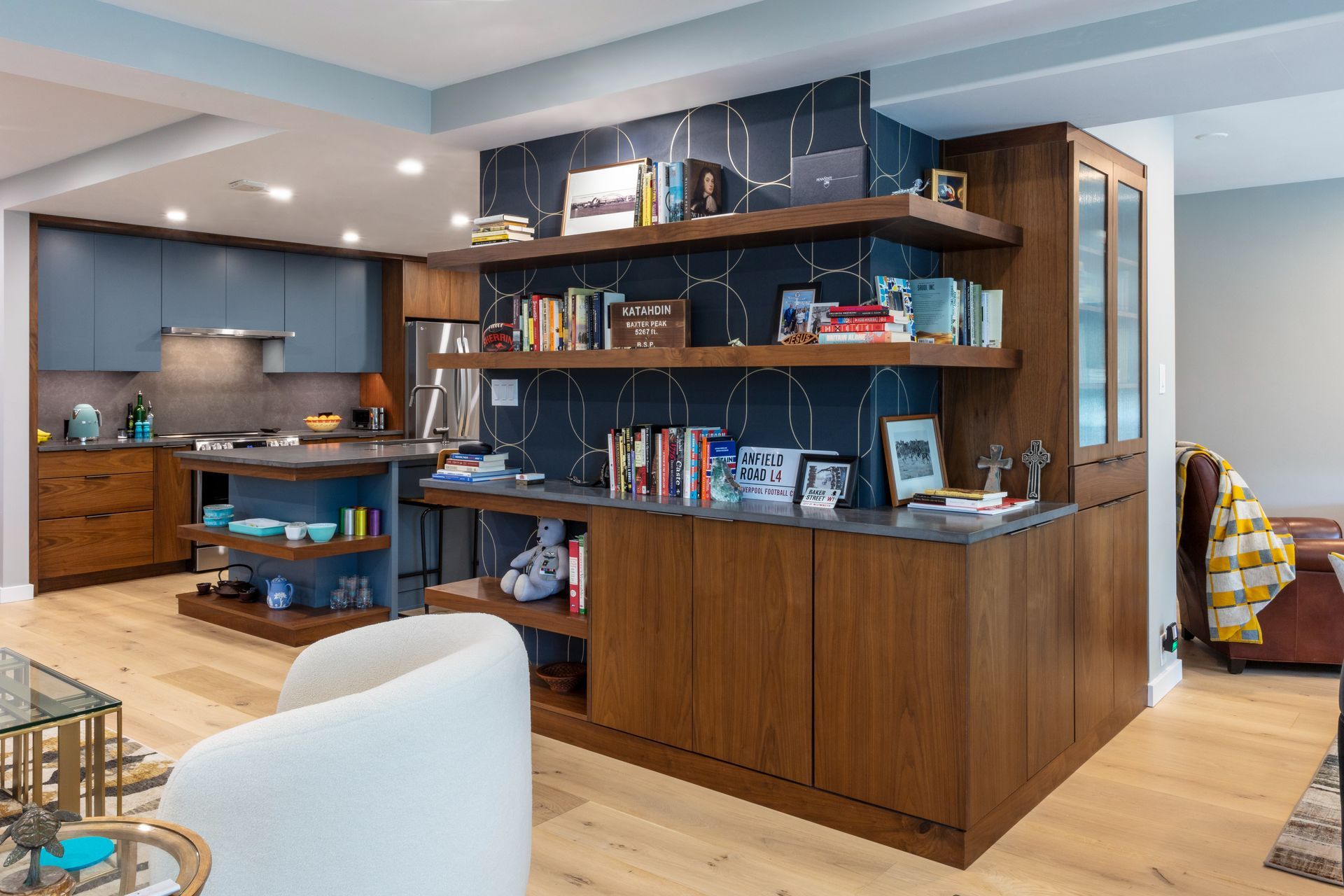 Modern open kitchen with wood cabinetry, floating shelves, and a central island in a bright home interior
