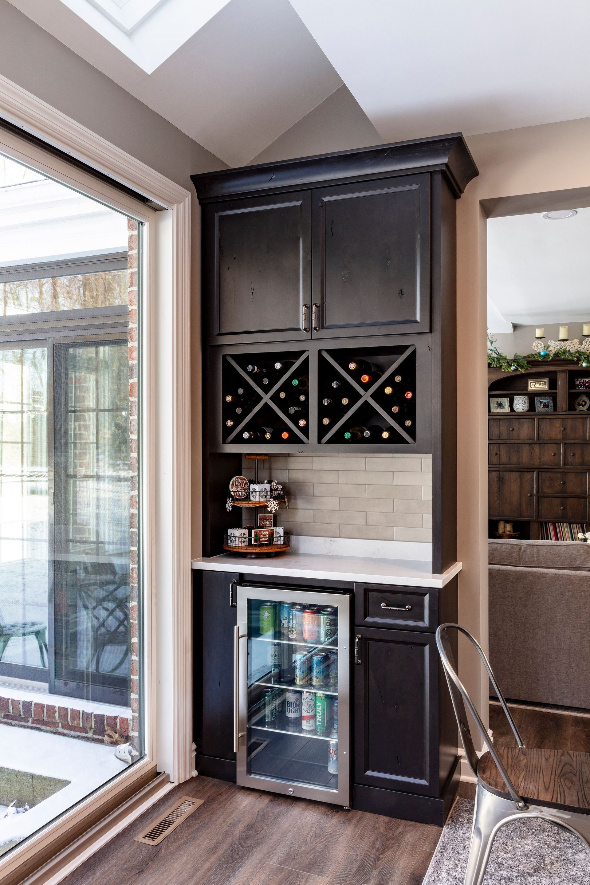 Built-in wine cabinet and mini fridge in a bright kitchen nook