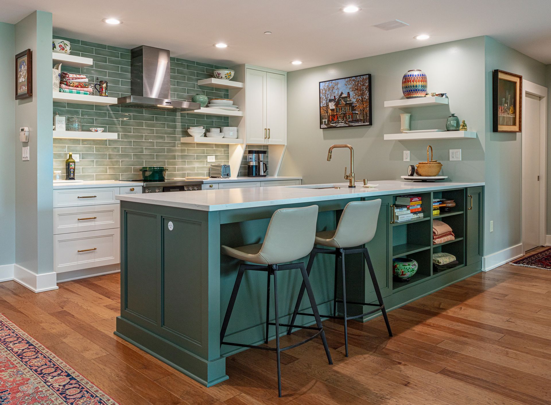 Modern kitchen with teal island, white cabinets, and hardwood floors
