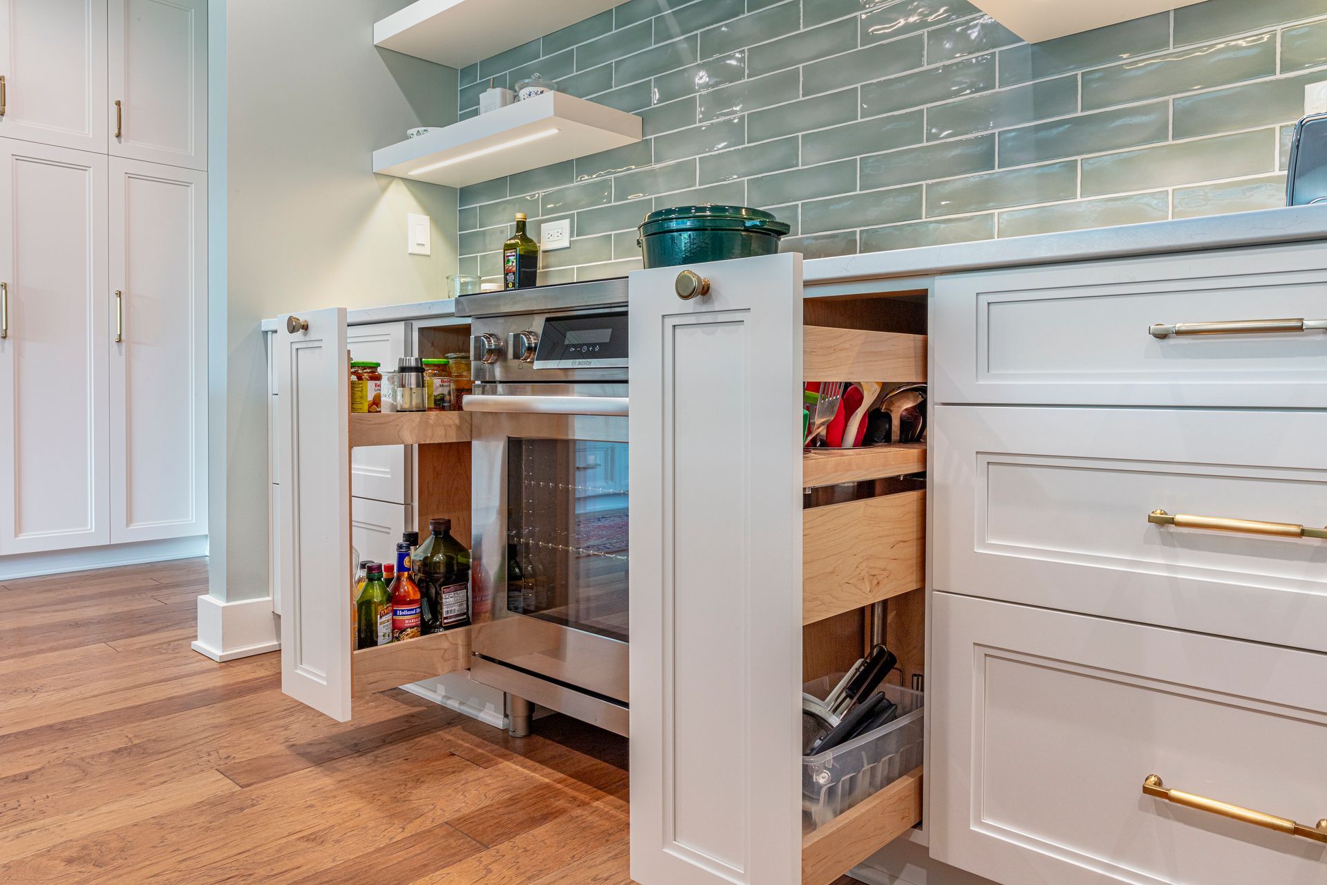 Modern kitchen with pull-out shelves, white cabinets, and a light blue tile backsplash