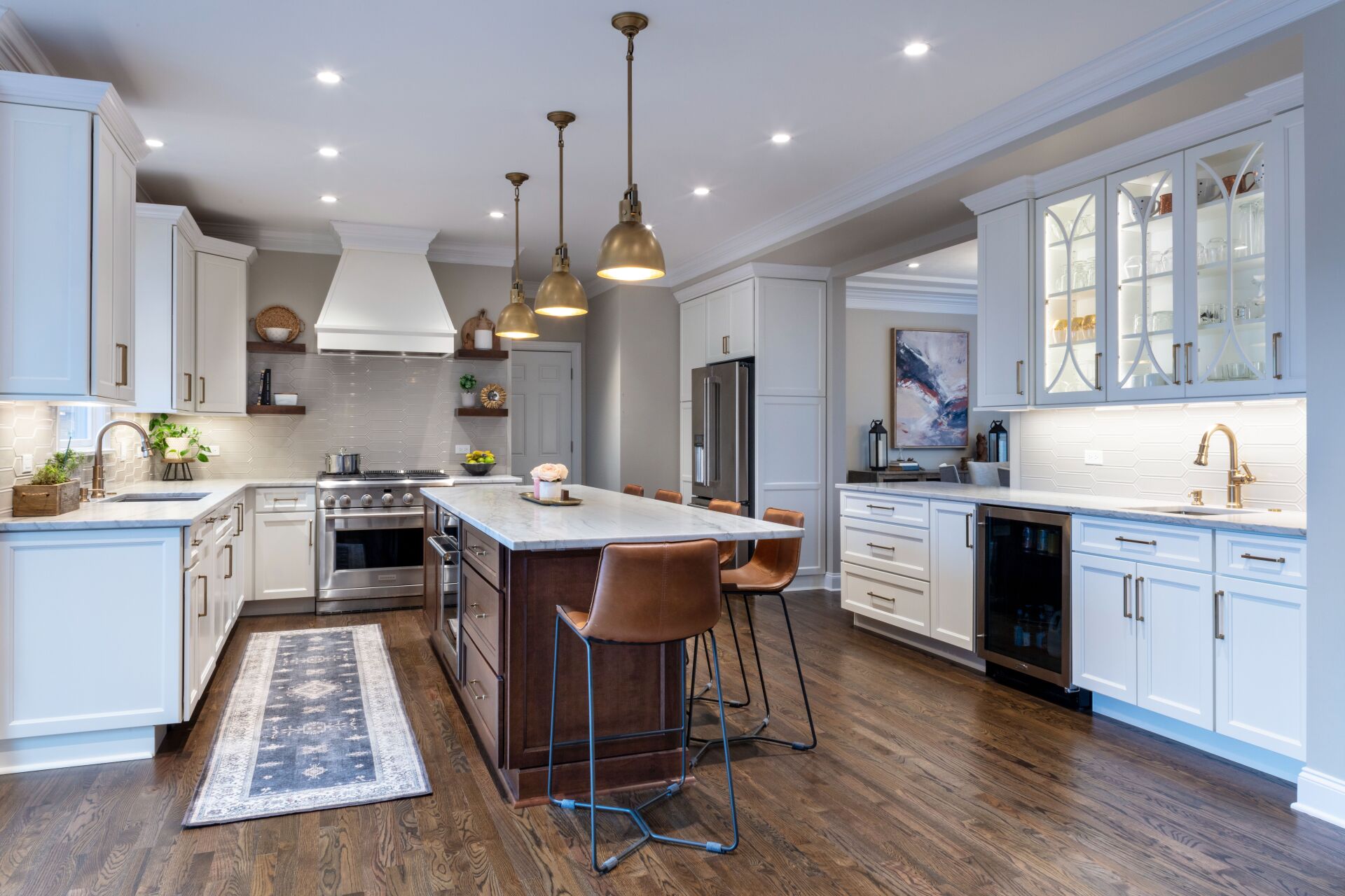 Bright modern kitchen with white cabinets, large island, pendant lights, and hardwood floors