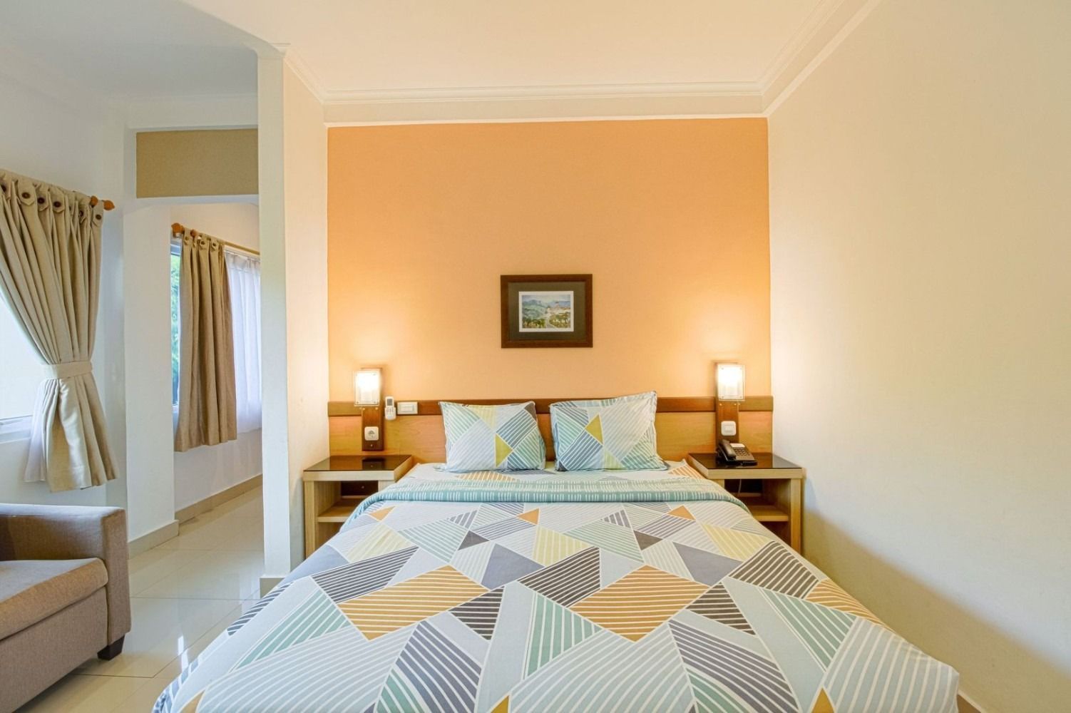 Bedroom with bed, nightstands, and orange accent wall.