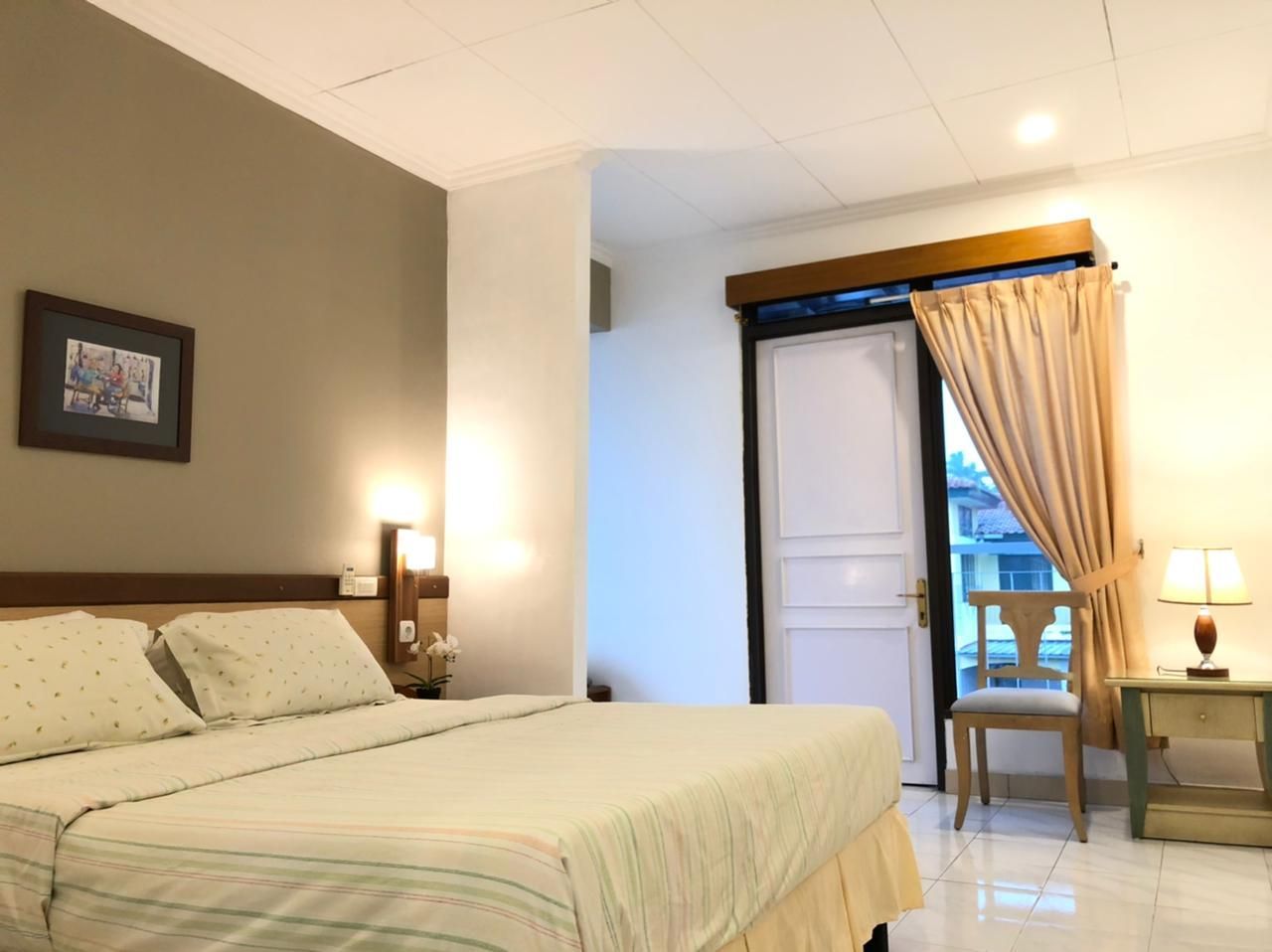Bedroom with bed, nightstand, and doorway with curtains. Neutral tones, soft lighting.