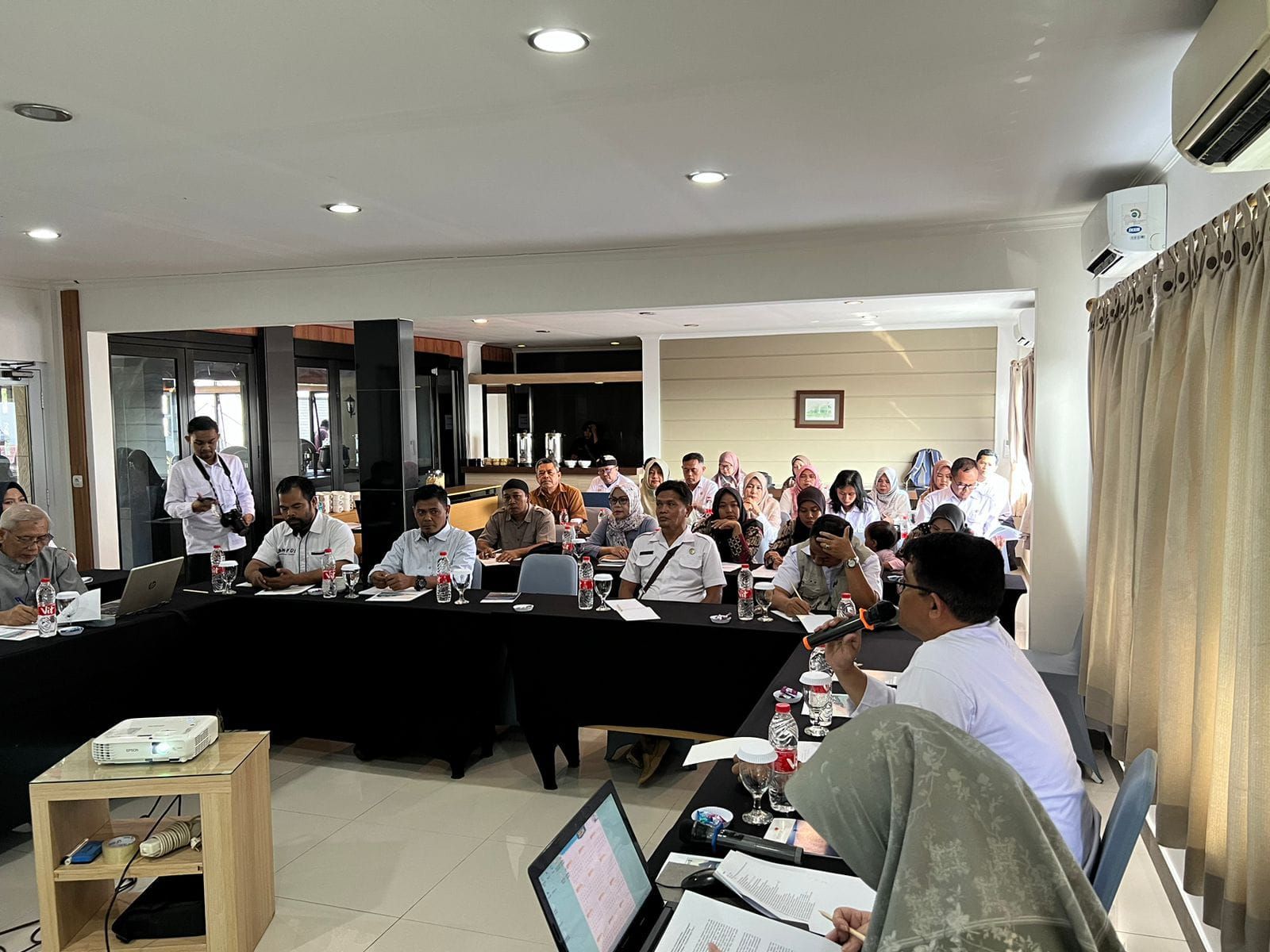 People seated at a conference table, a presentation in progress.