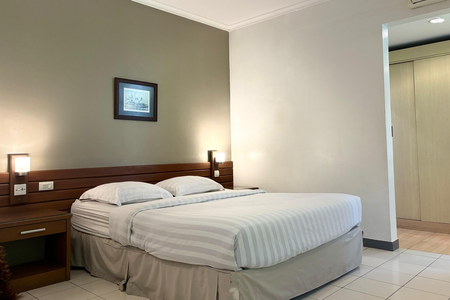 Hotel bedroom with a bed, nightstand, and wall art.