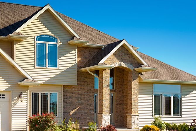 House Exterior — Waterloo, IA — Town & Country Home Improvement Modern tan brick home.