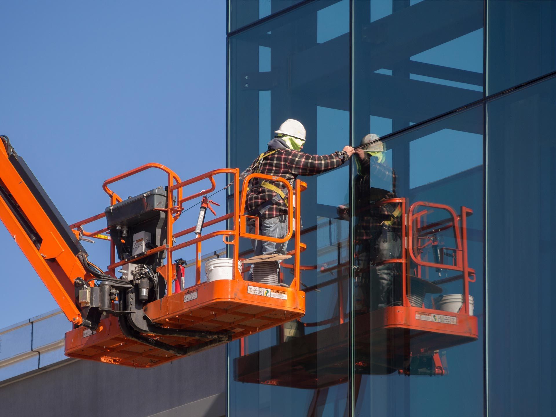 Window installer on a commercial building. Window installer on a commercial building.