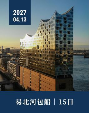 Sunlit modern glass building beside a waterfront at sunset