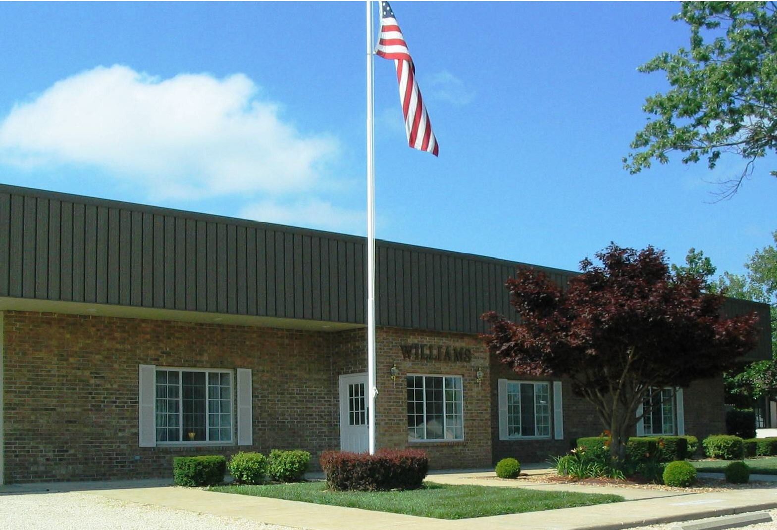 Brick building with an American flag on a pole under a blue sky
