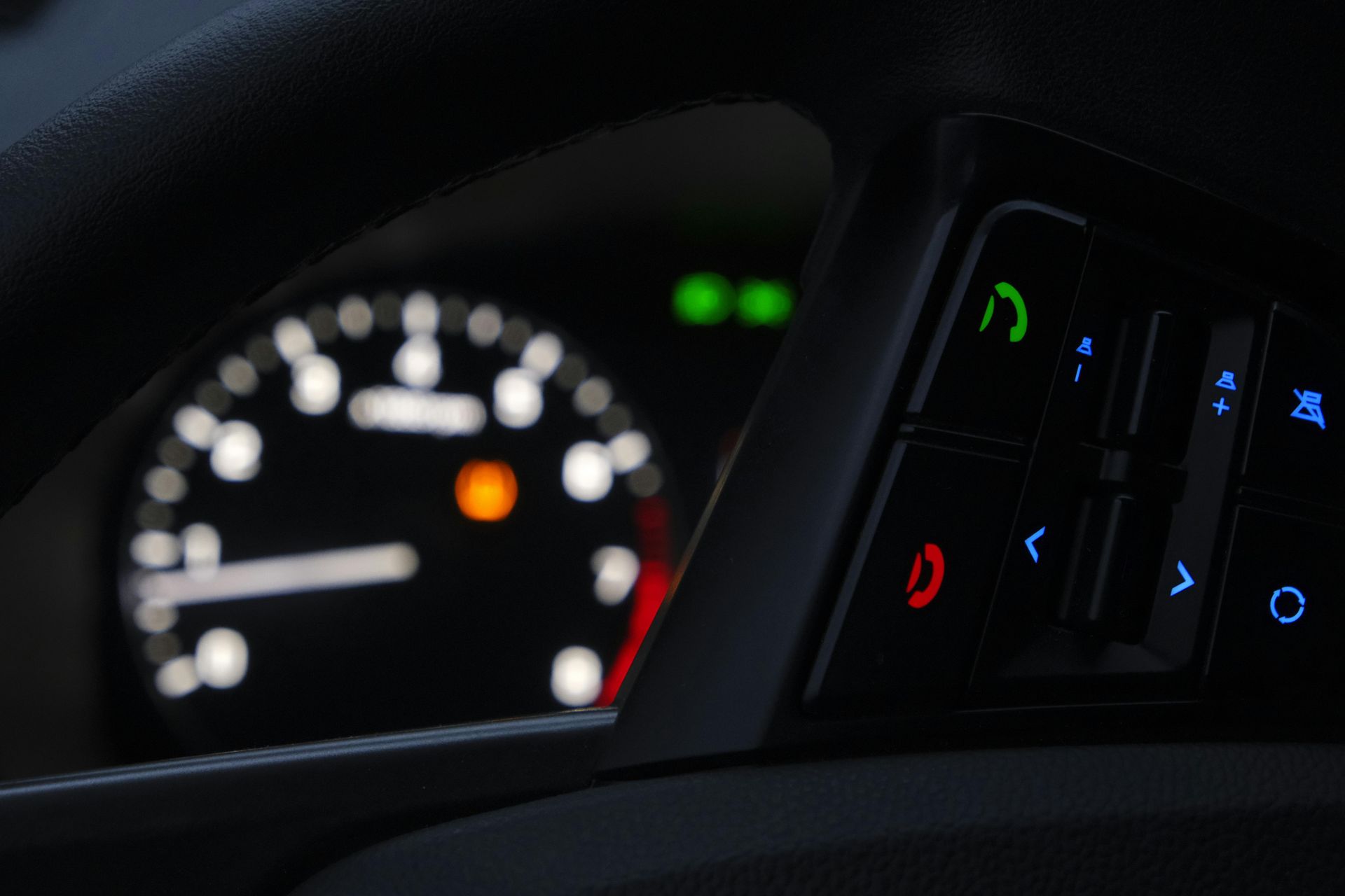 Car steering wheel with engine lights in the background