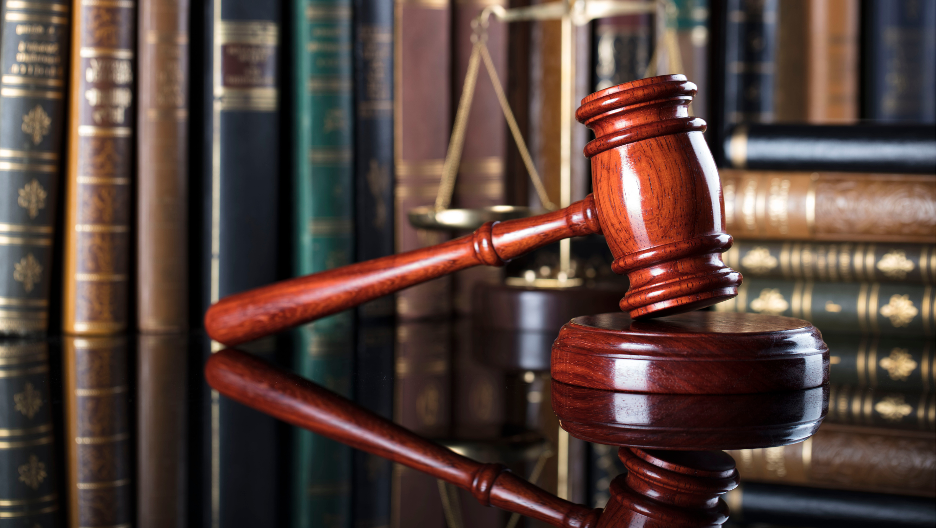 Scope out The Felty Legal Brief Blog. Wooden judge’s gavel on a reflective surface with law books in the background