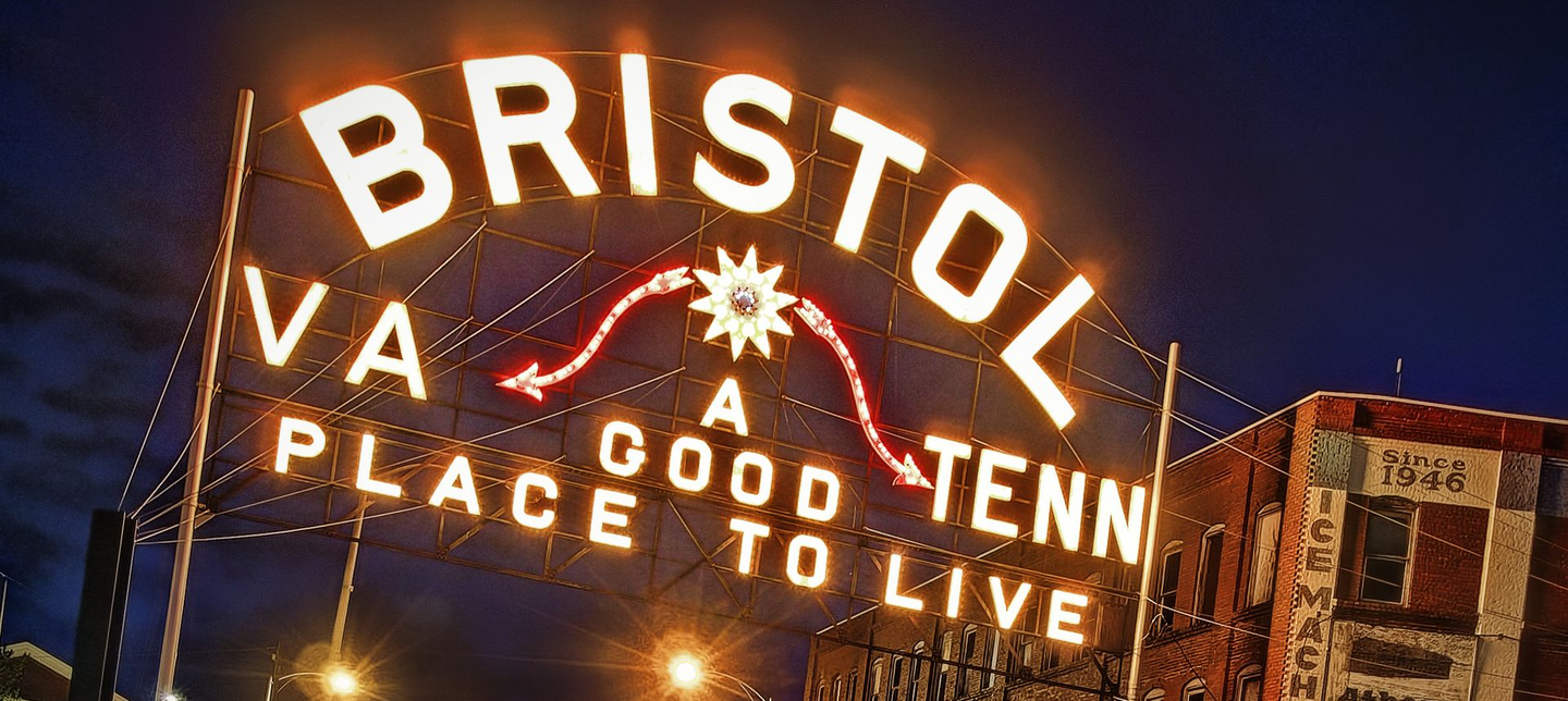 Bristol “A good place to live” sign glowing at night over State Street border road taken from the Virginia side.