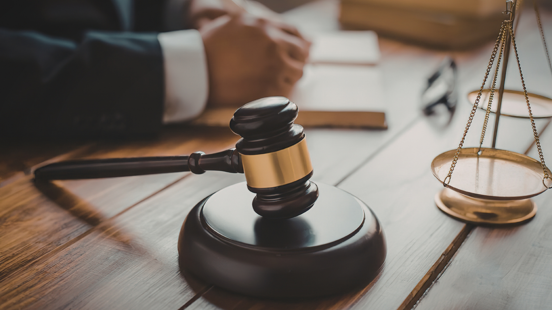 Lawyer’s desk with gavel, scales of justice, and paperwork in a courtroom setting