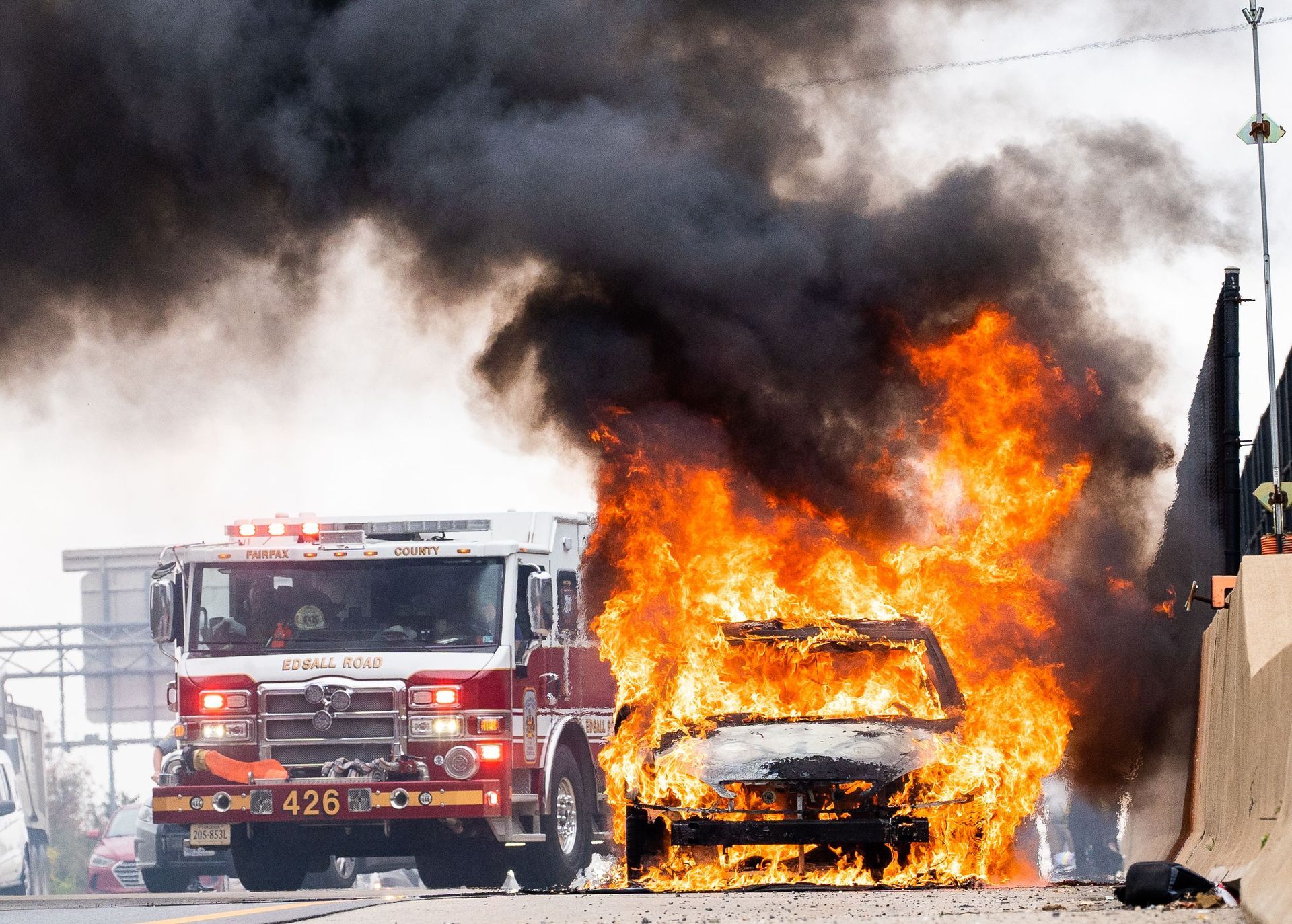 Do you deserve compenssation? Learn more! Fire truck and car engulfed in flames with thick black smoke on a road
