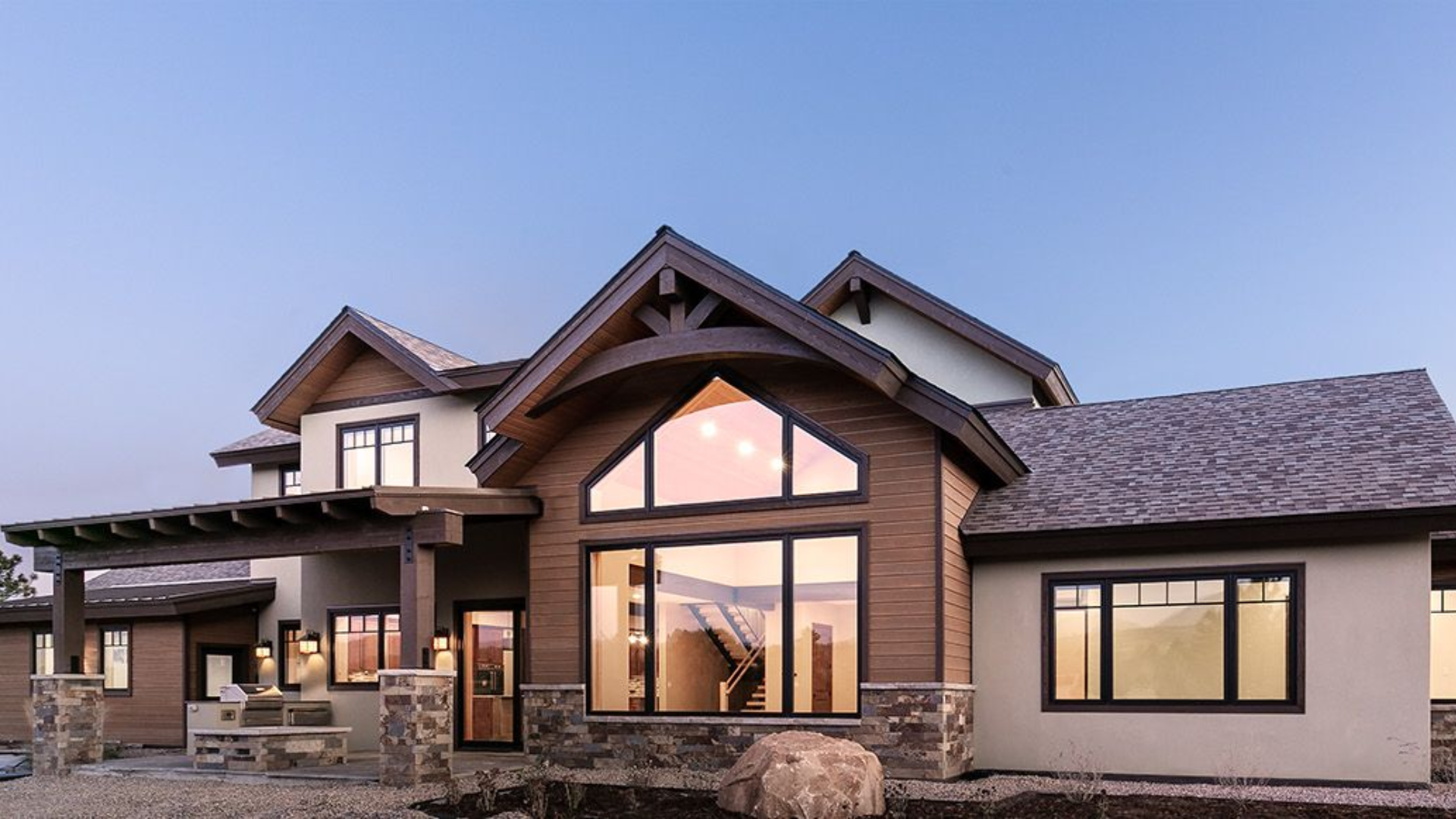 A large house with a lot of windows is sitting on top of a hill.