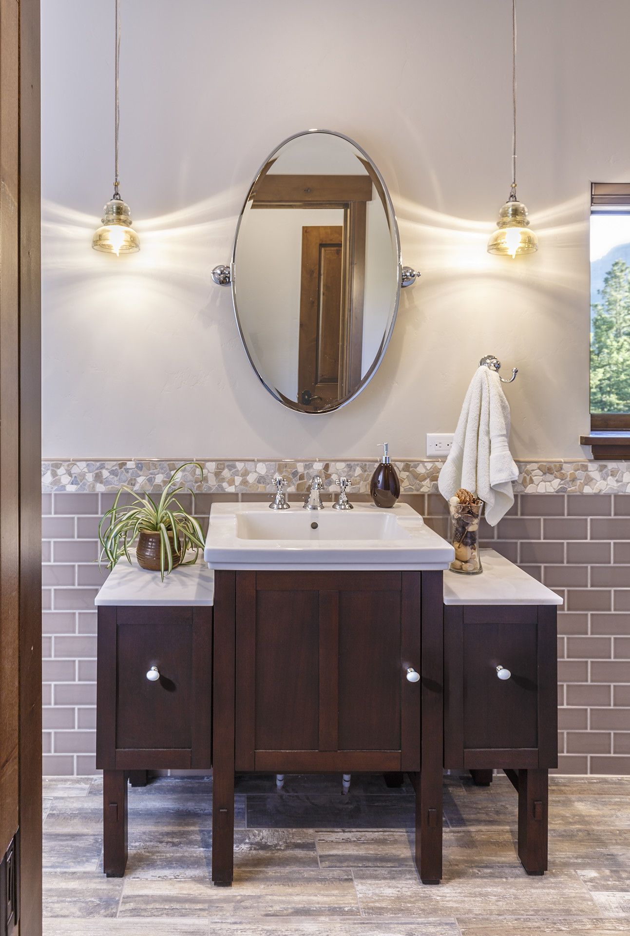 A bathroom with two sinks , a mirror and a window.