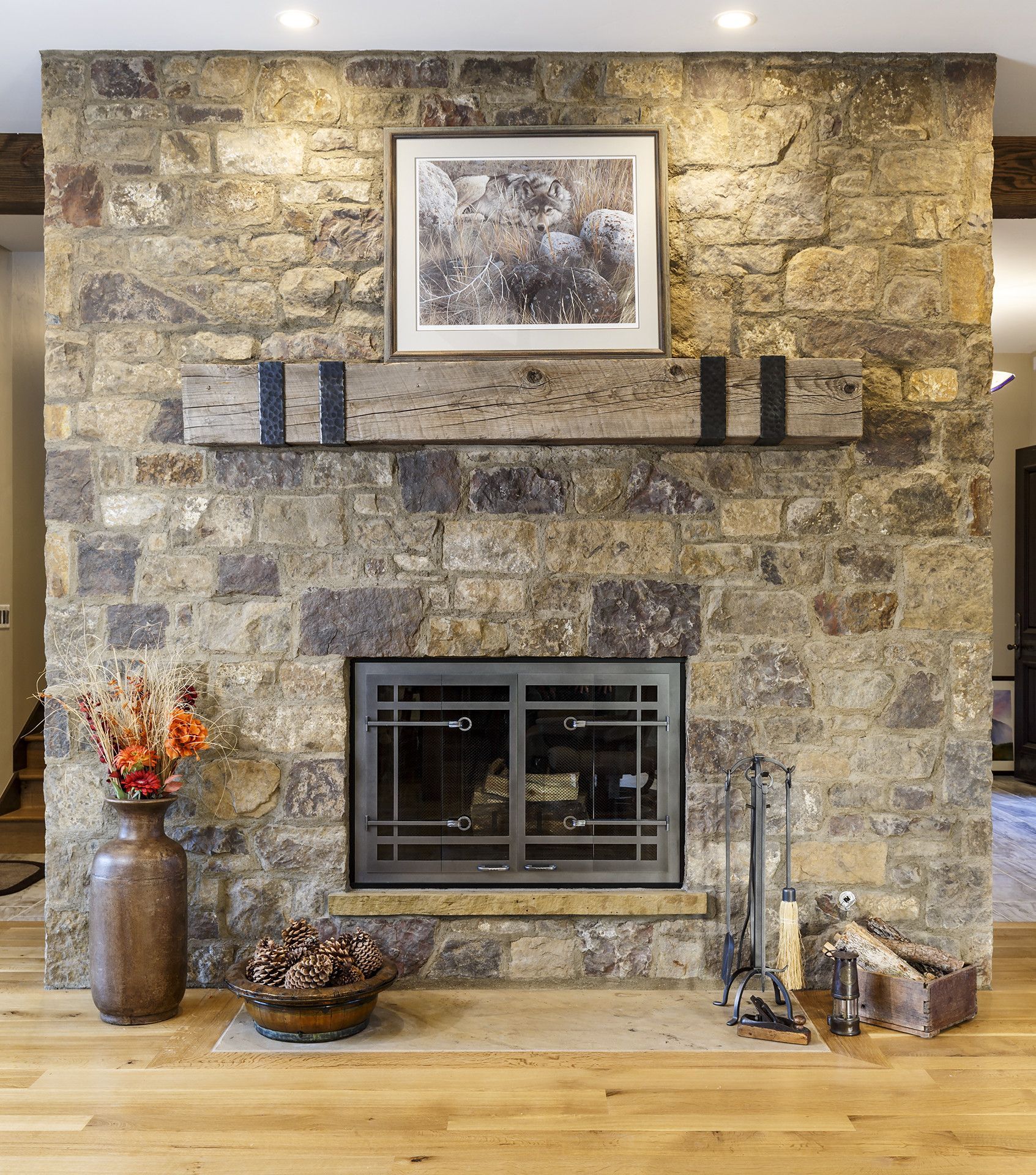 A large stone fireplace with a picture above it