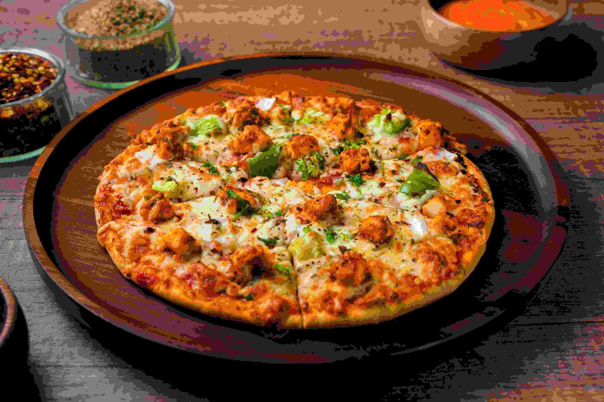 a pizza is sitting on a wooden plate on a table .