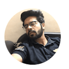 a man with a beard and glasses is sitting in a chair .