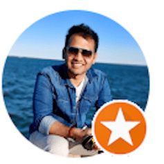 a man wearing sunglasses is sitting on a boat in the ocean .