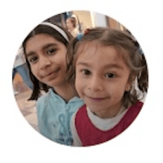two little girls are posing for a picture together in a circle .