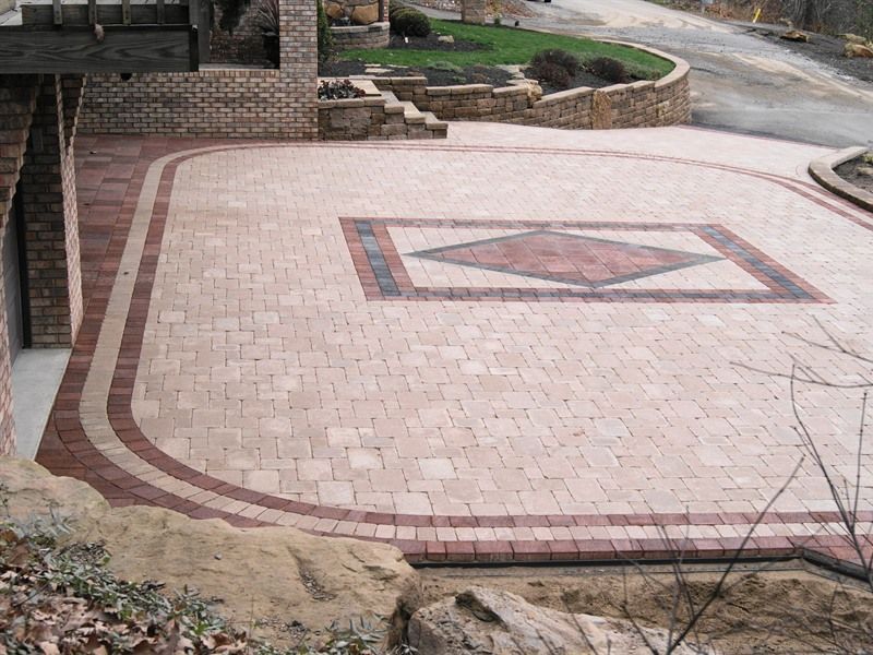 Brick paved driveway with red and tan pavers, decorative center.