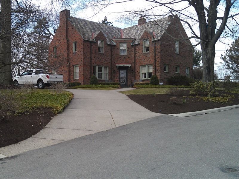 Brick house with a long driveway. A white pickup truck is parked to the left.