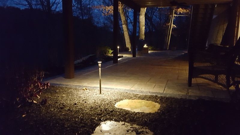 Pathway illuminated at night by several ground lights.