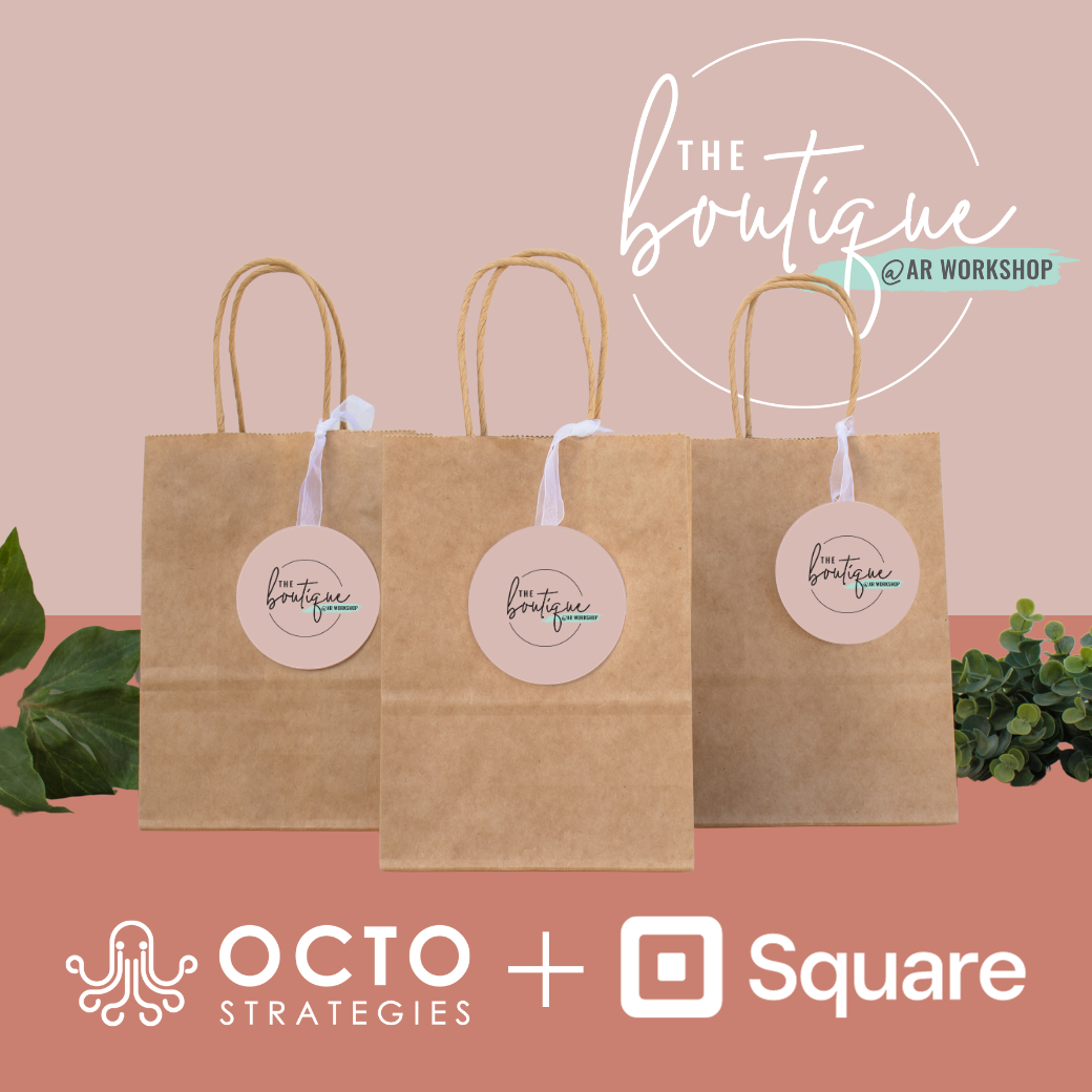 Three brown paper bags with stickers that say the boutique