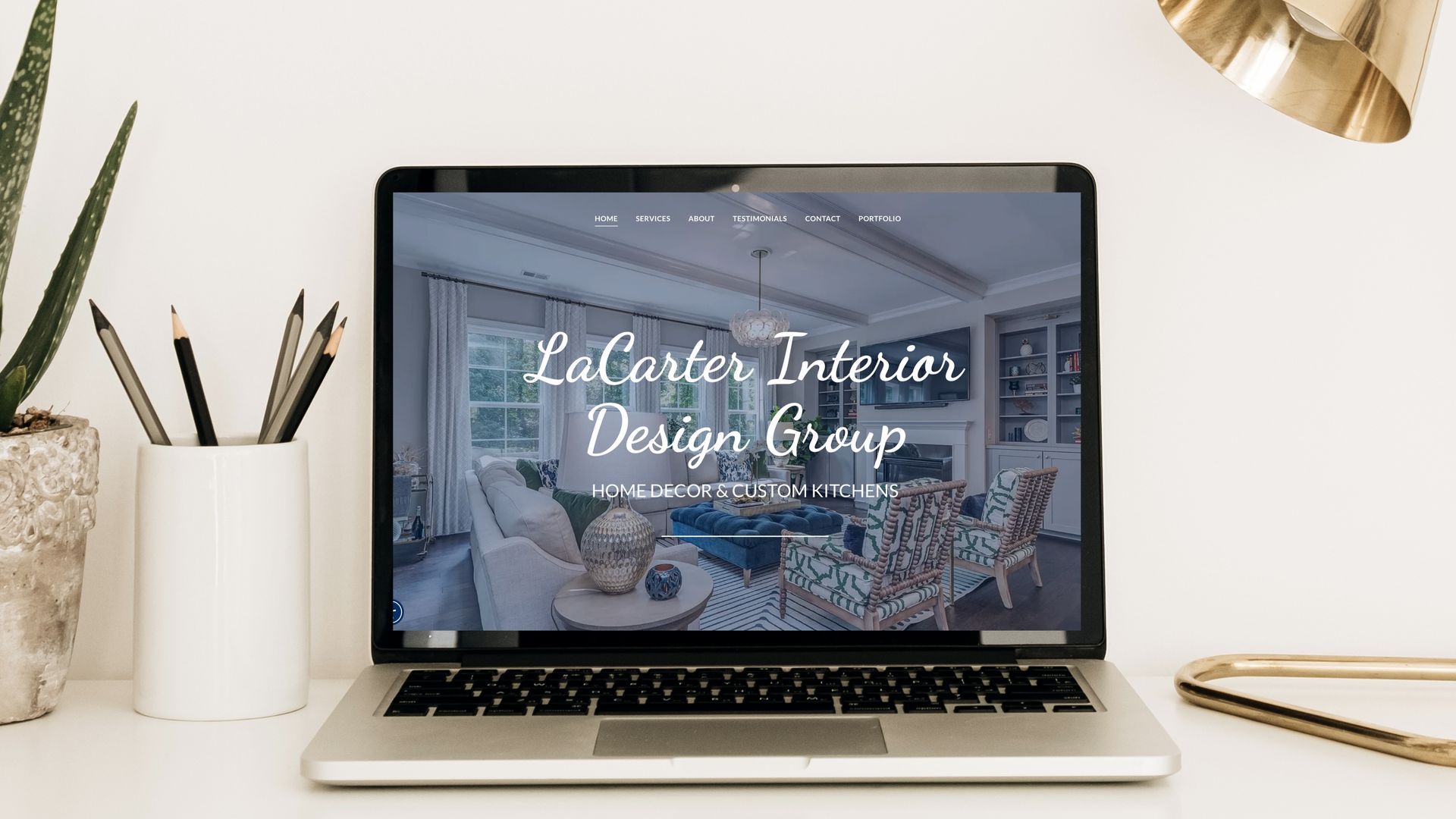 A laptop computer is open to a website for la carter interior design group.