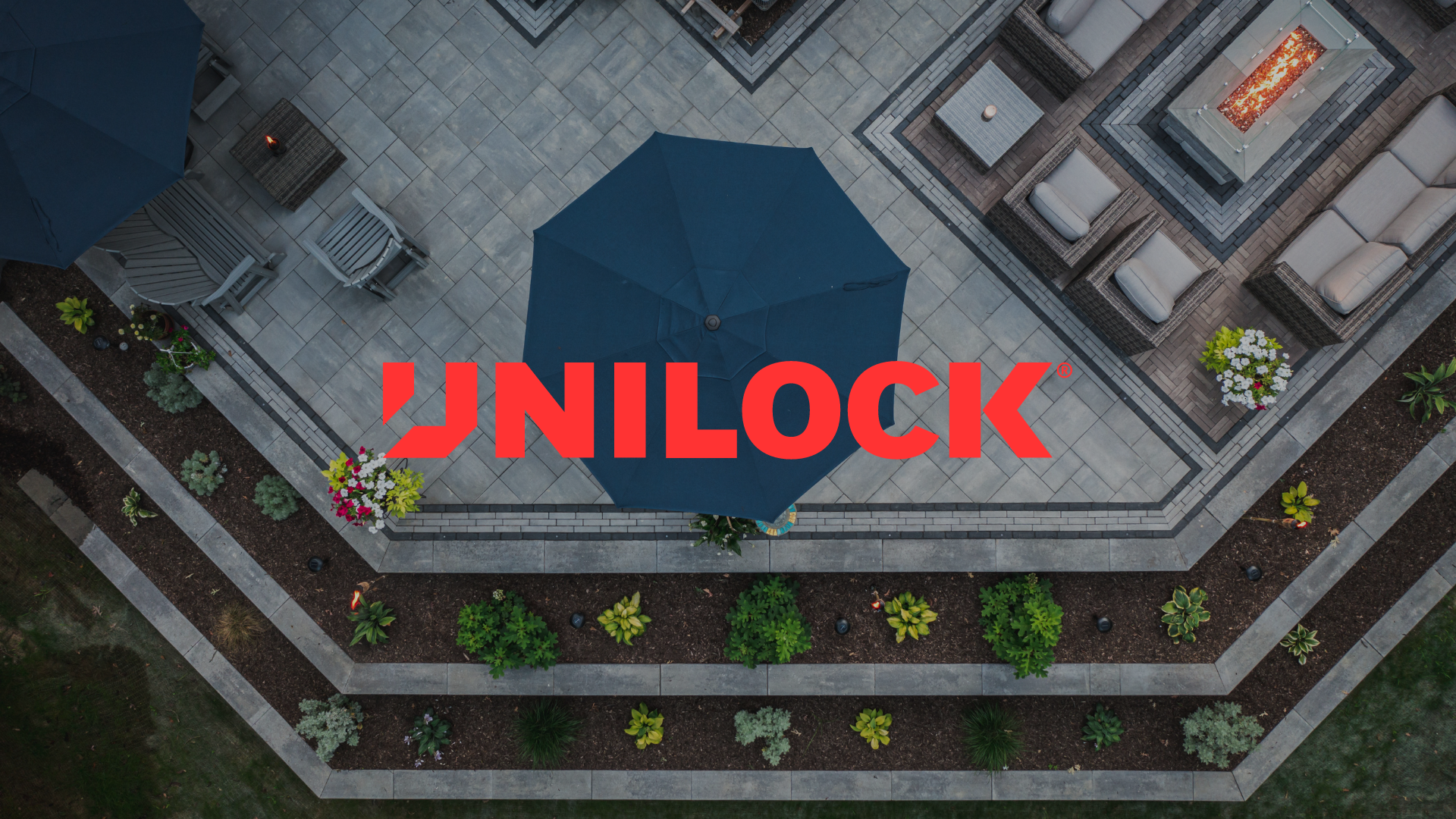 An aerial view of a patio with a blue umbrella and a fire pit.