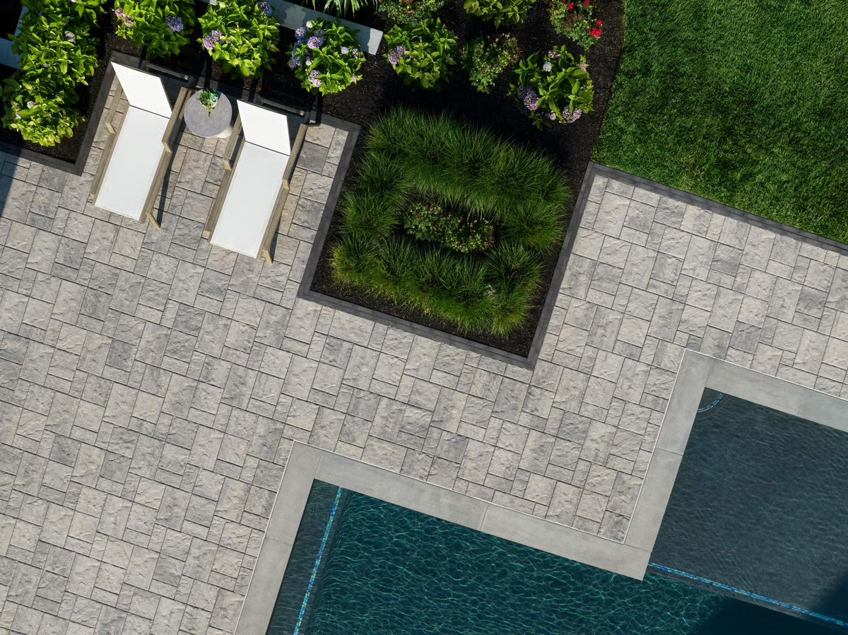 A brick driveway with a garage in the background