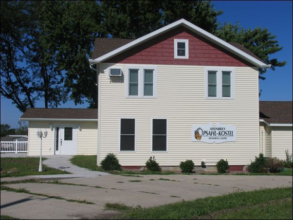 A white house with a red roof and a sign that says prairie home