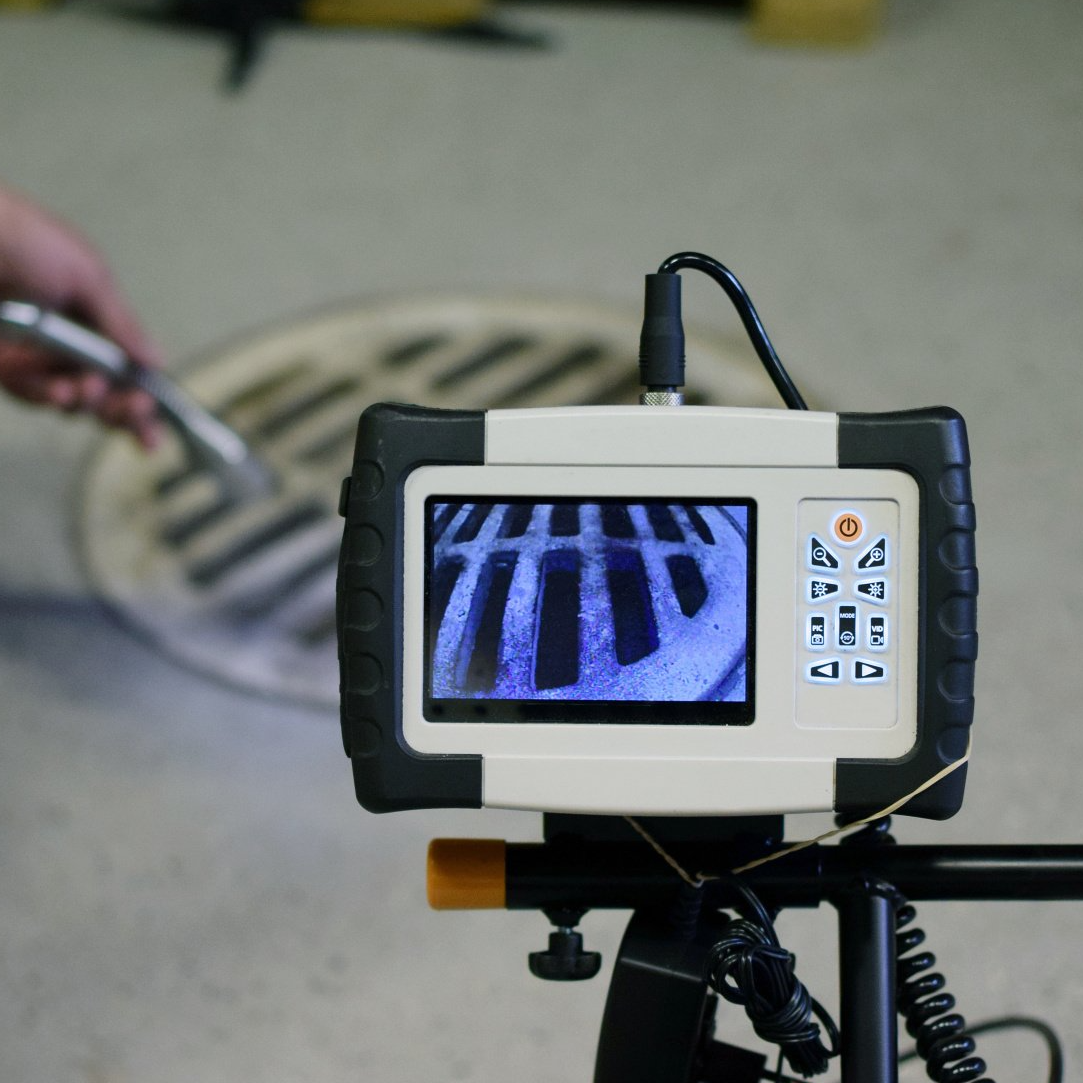 A manhole cover is being inspected by a camera