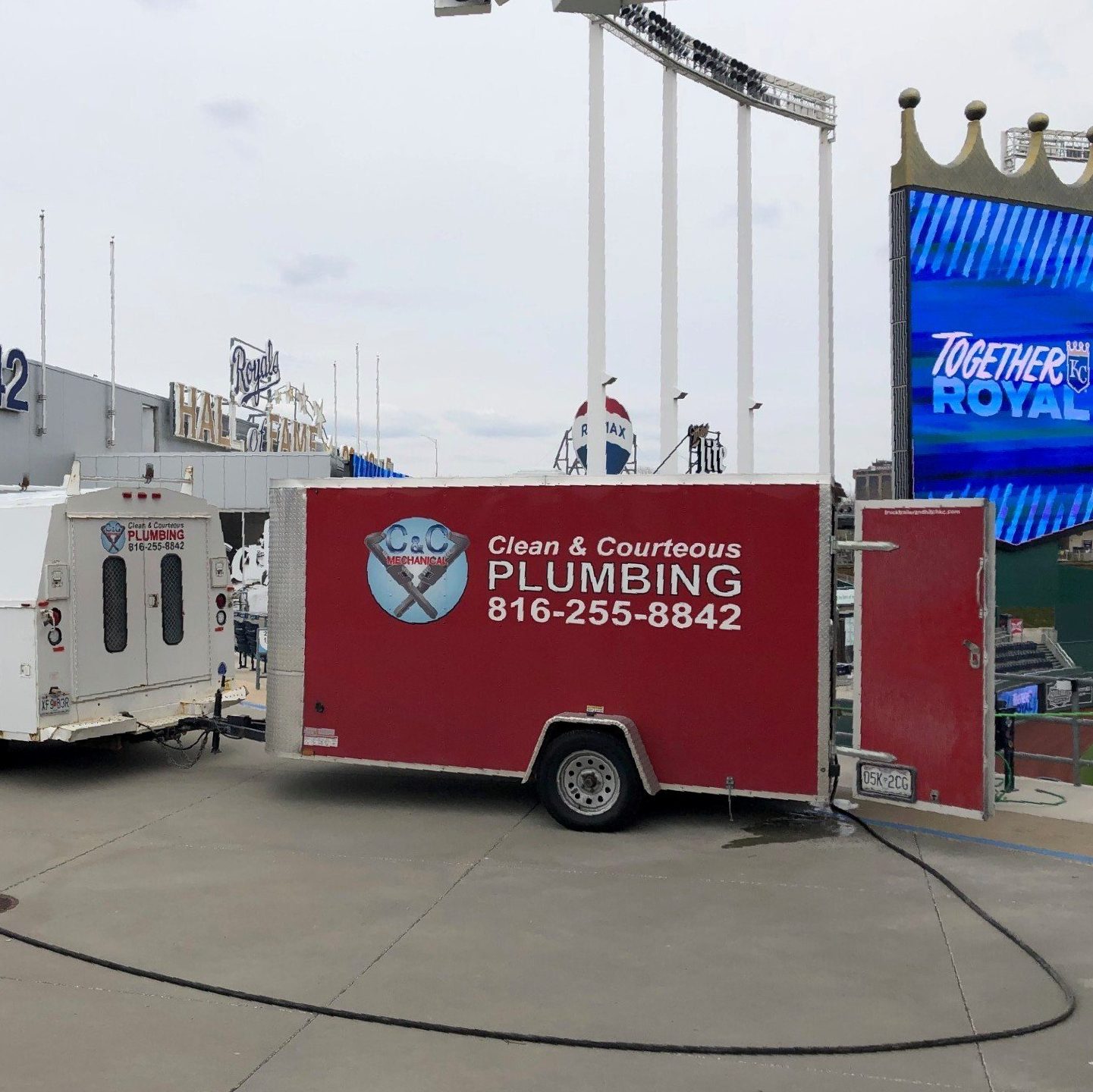 A red trailer that says clean & courteous plumbing on it