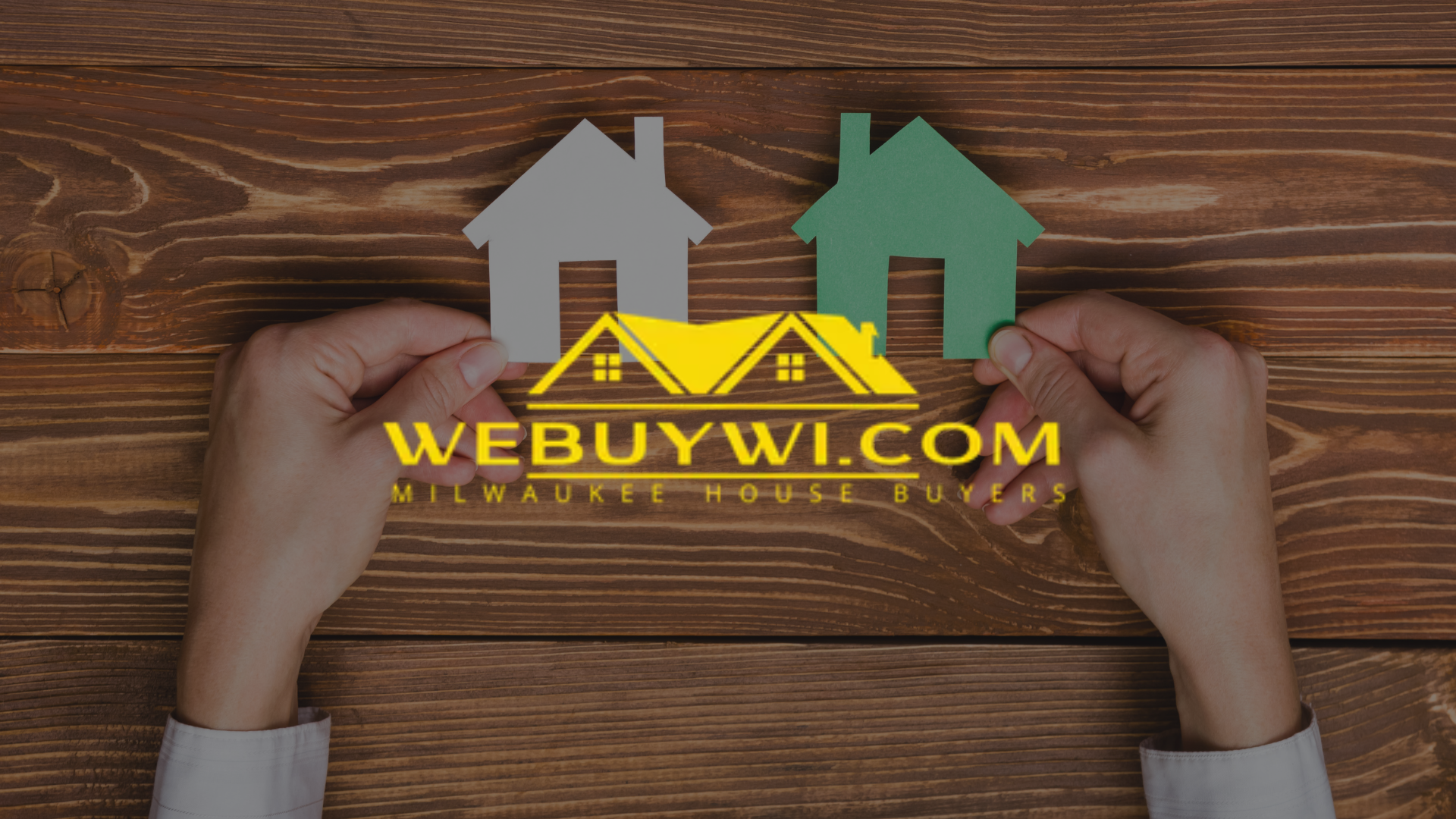 Hands holding cutout houses, one gray, one green, with logo