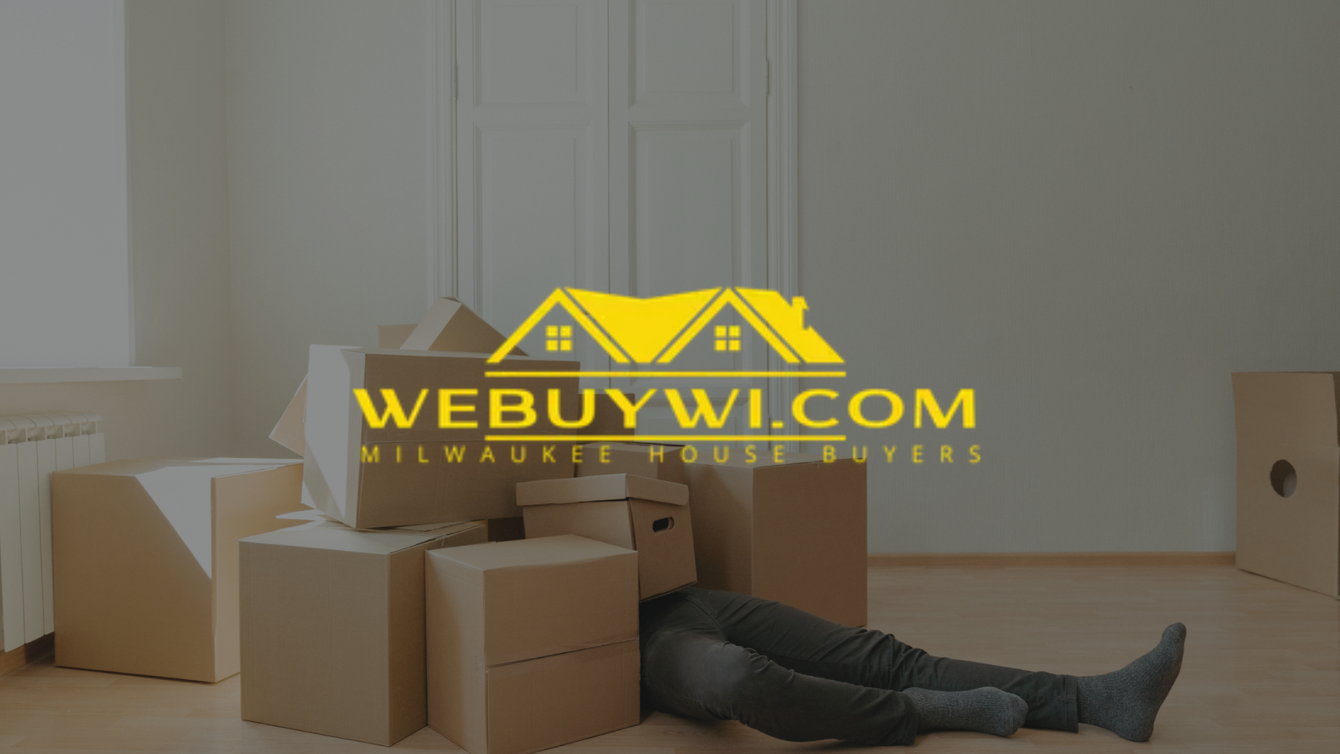 Person buried under moving boxes, next to a stack of boxes. The website logo for
