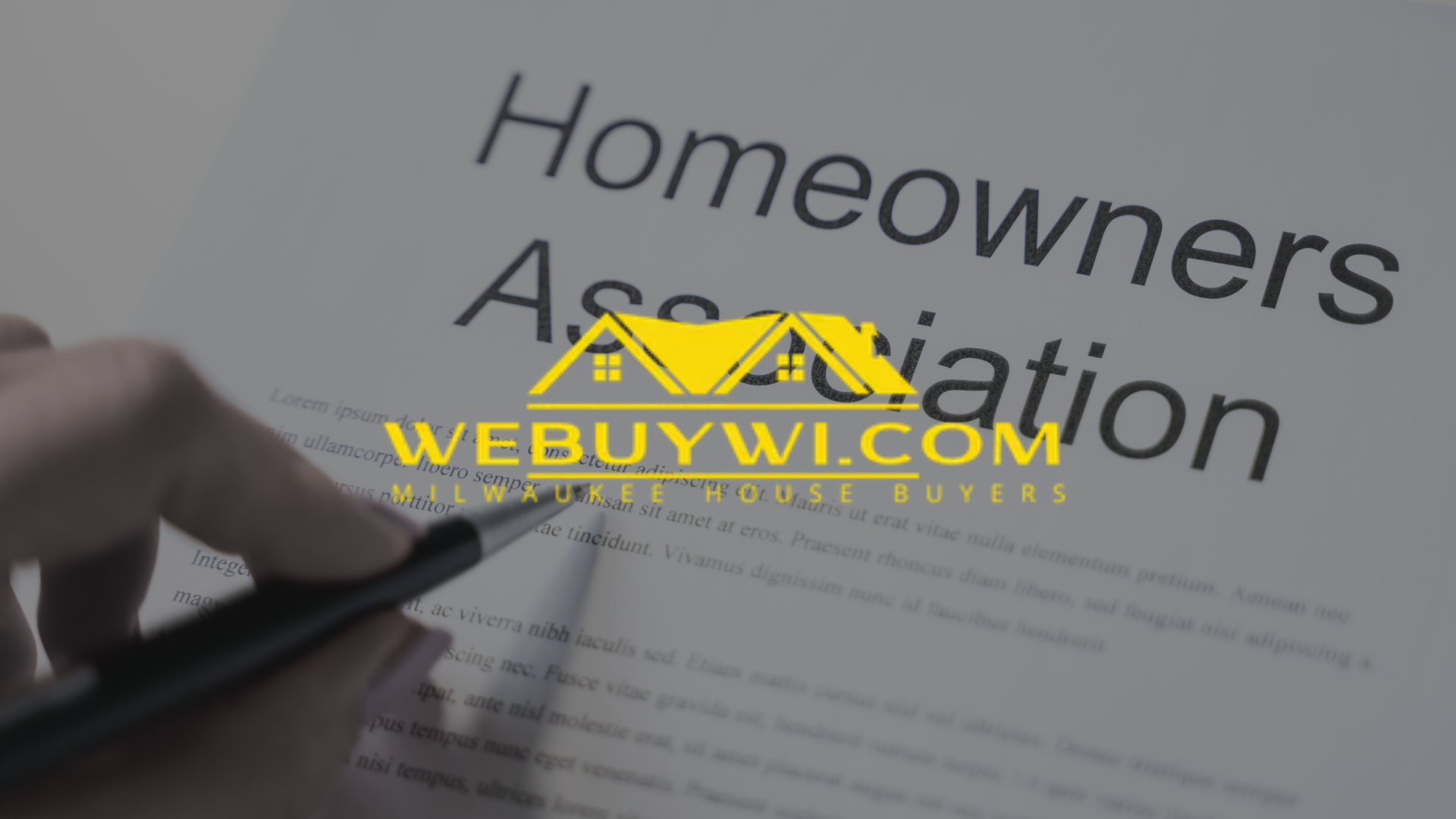 Hand holding a pen over a document titled
