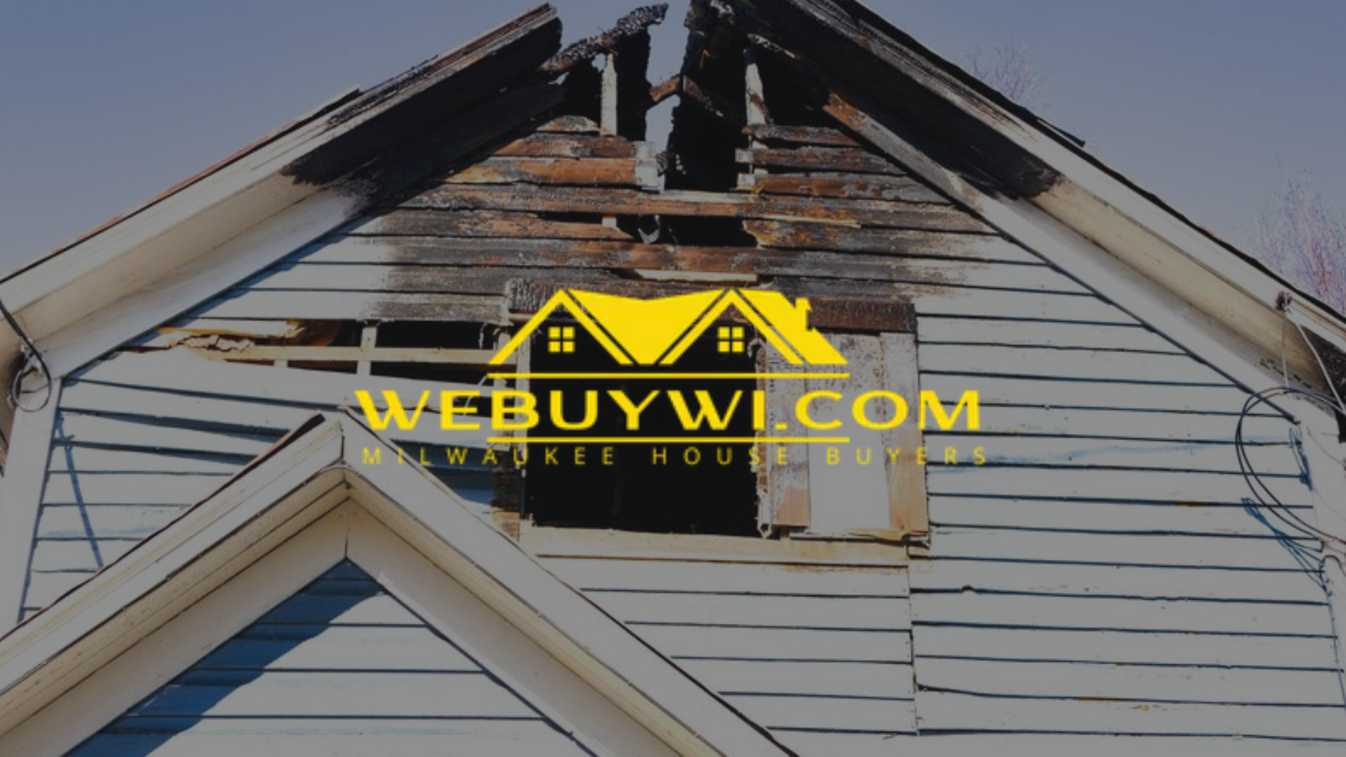 A damaged greenfield wi house with a partially collapsed roof, likely from a fire. The logo for