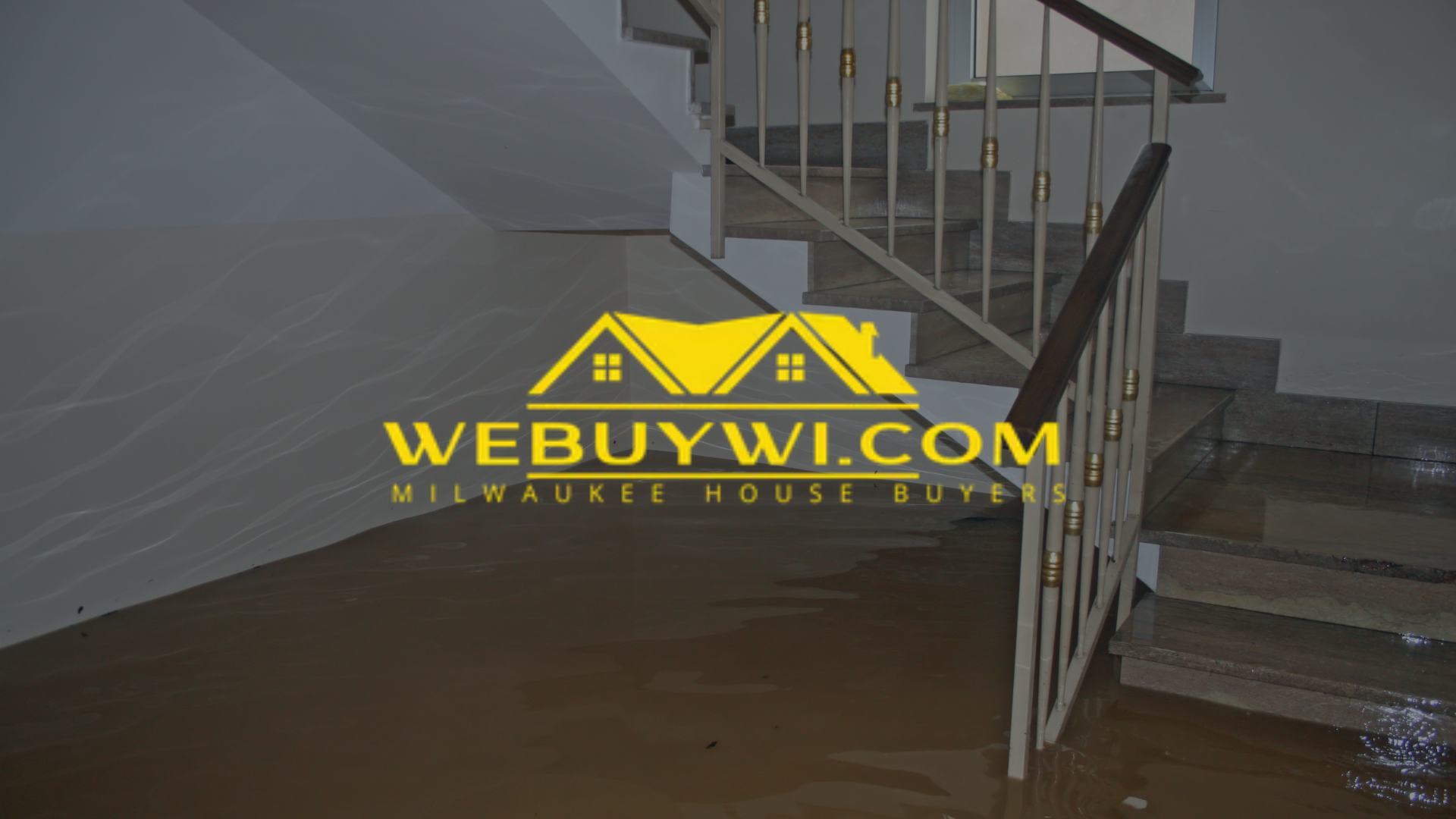 Flooded basement with stairs, tan water and wall, light handrail, and a “WE BUY WI” logo.