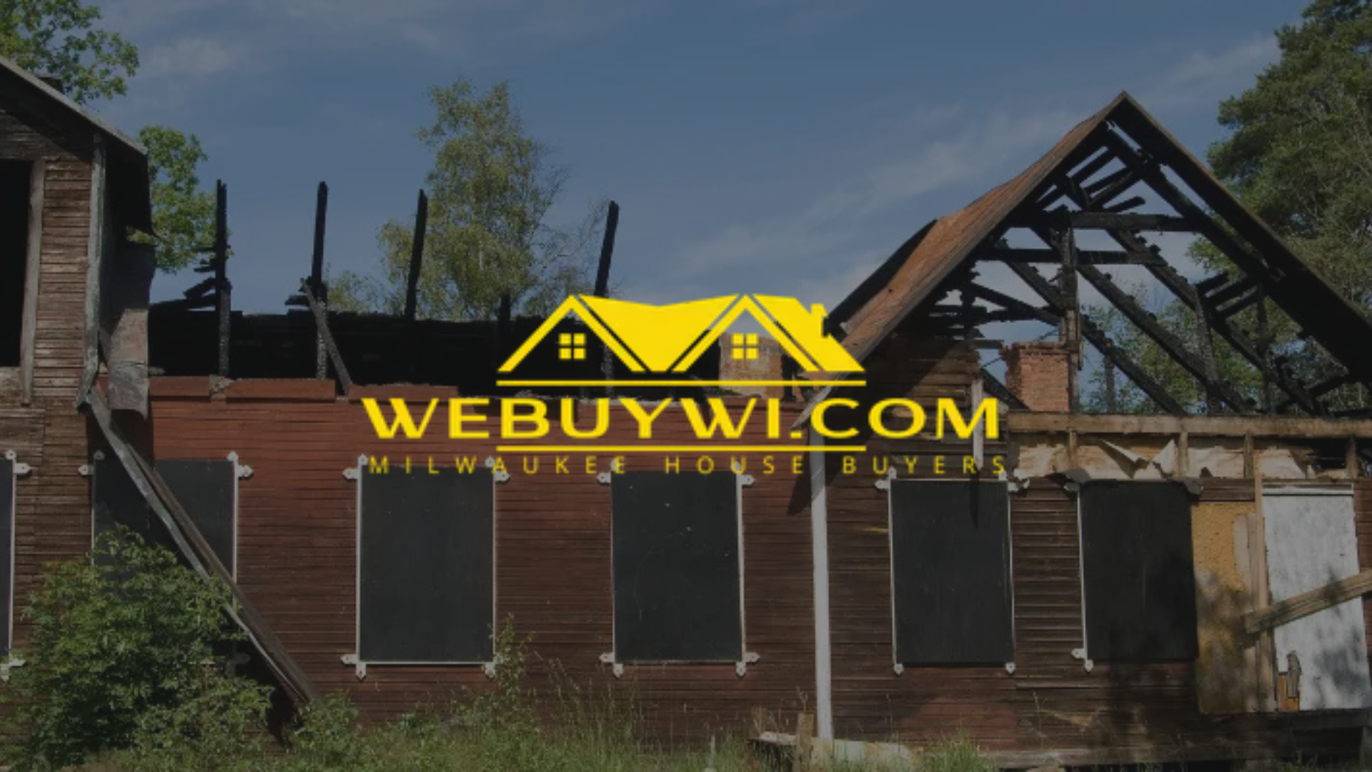 Burned-out, boarded-up house in disrepair with a
