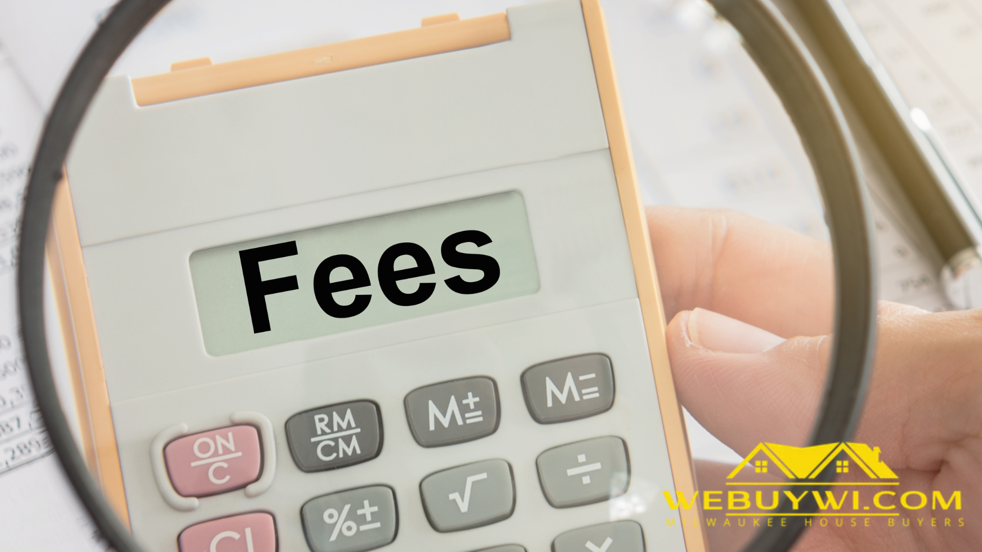 A person is holding a calculator with the word fees on it.