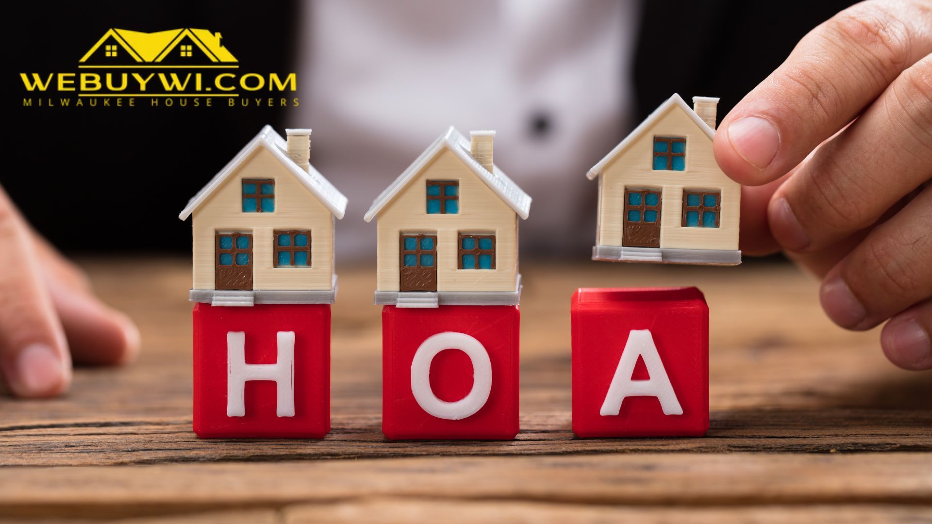 A person is putting houses on top of red blocks that say hoa.
