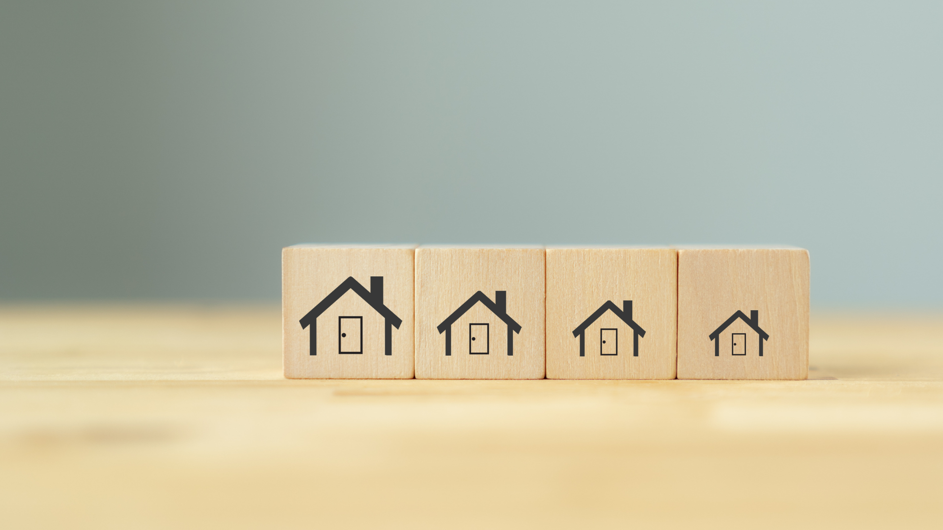 A row of wooden blocks with houses on them on a wooden table.