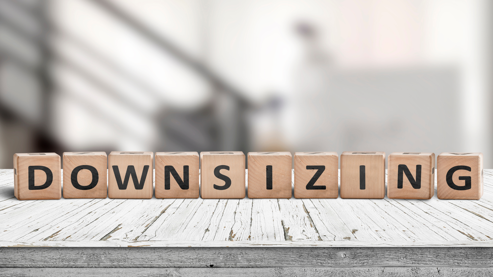 The word downsizing is written on wooden blocks on a table.