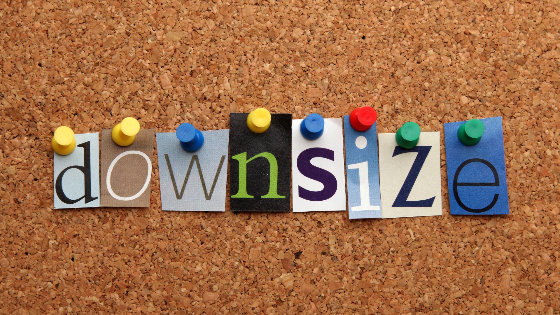 The word downsize is pinned to a cork board