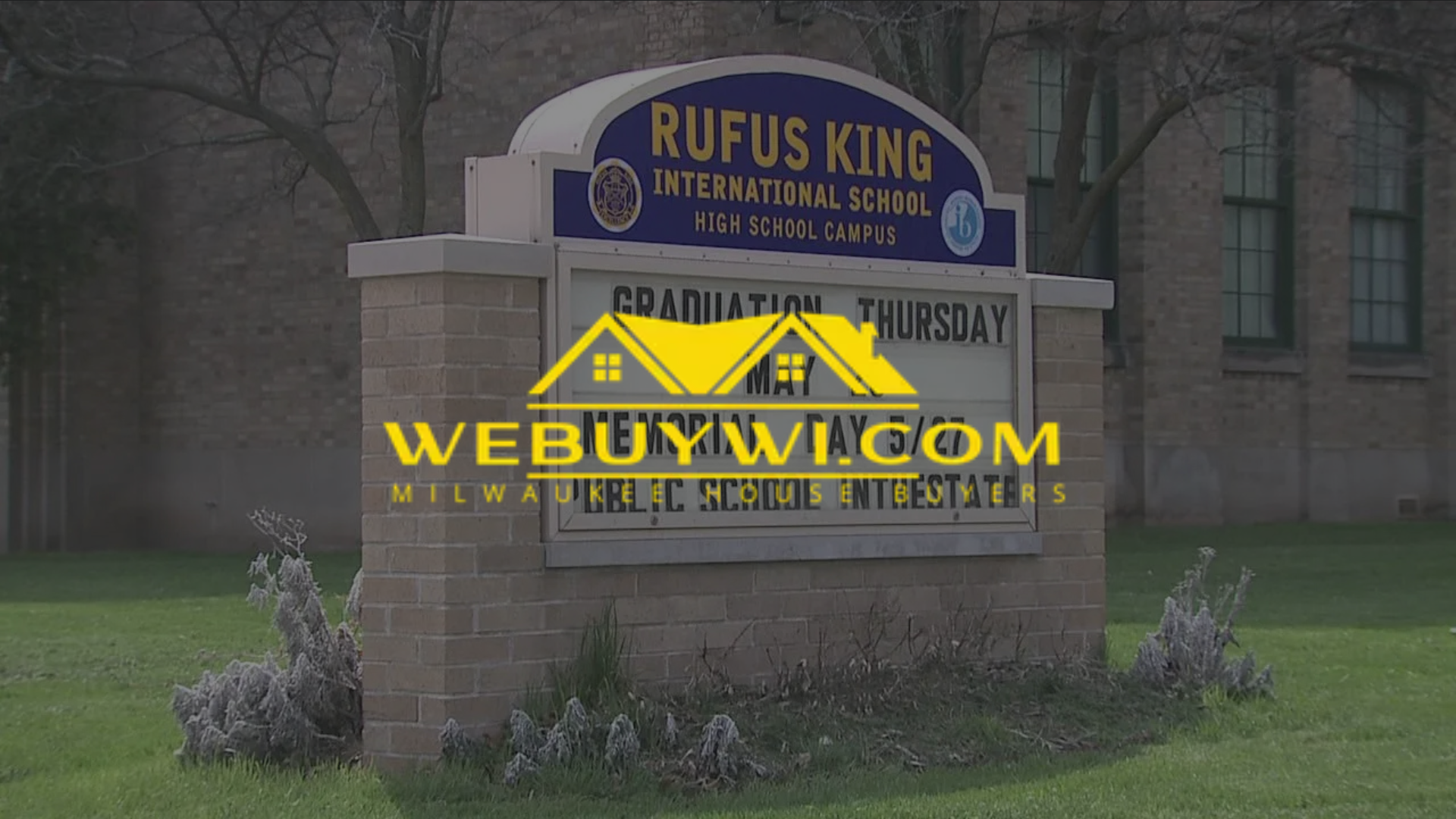 Rufus King International High School sign; brick structure, blue, gold lettering. Webuywi advertisement
