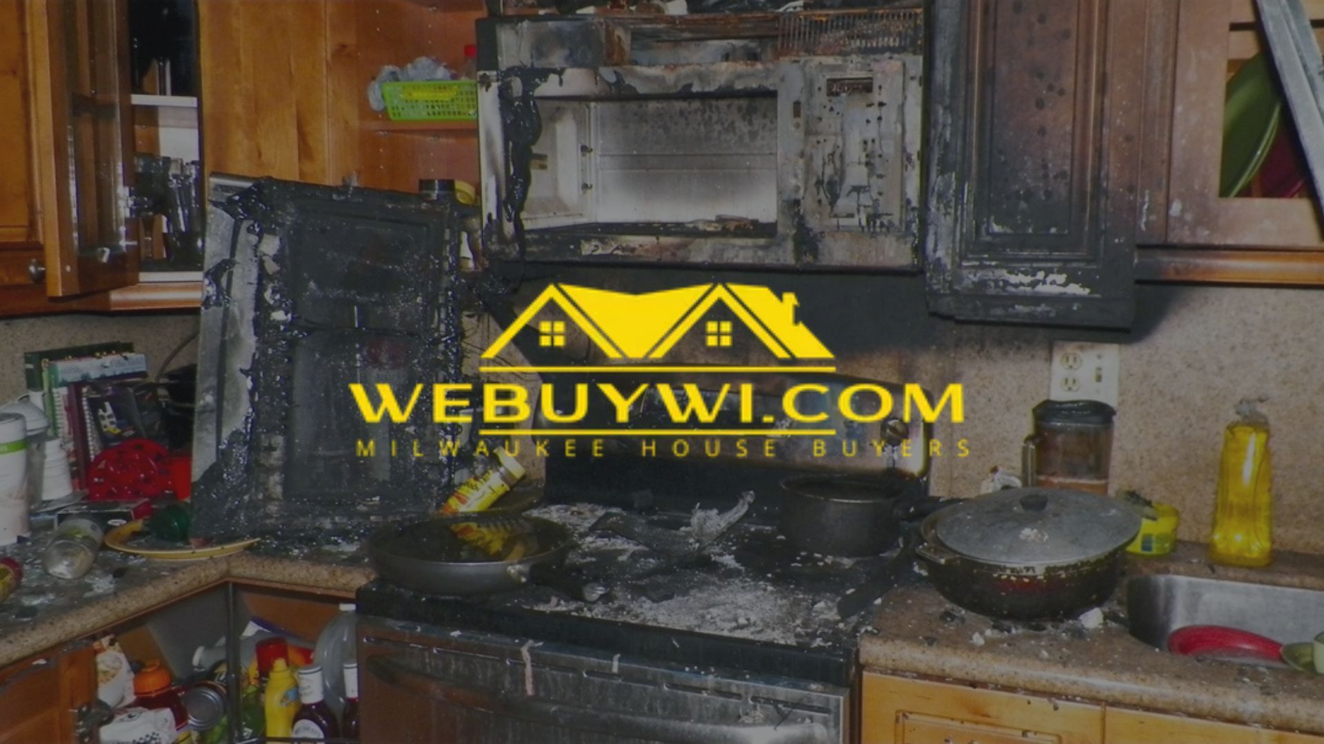 Kitchen ruined by fire, charred appliances and cabinets, debris on counters.