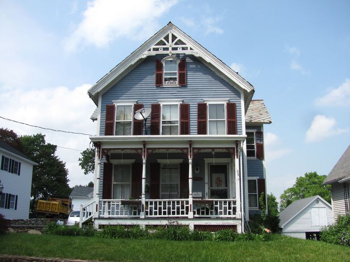 A large house with a porch and shutters has the word miami on the side of it