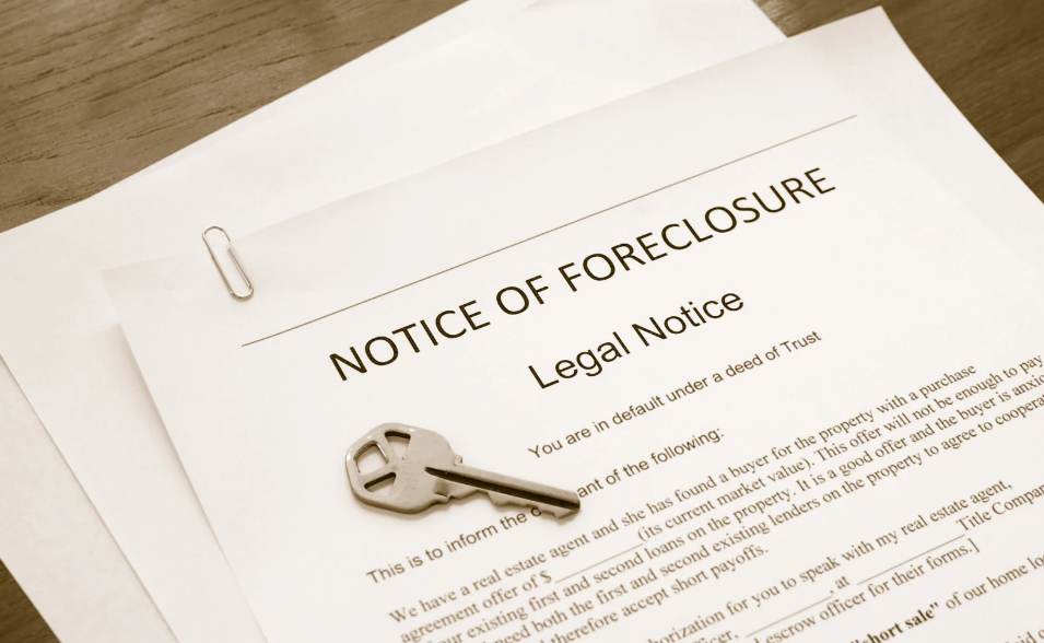 A notice of foreclosure with a key on top of it
